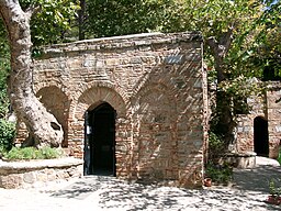 A stone building with arched doorway with House of the Virgin Mary in the background

AI-generated content may be incorrect.
